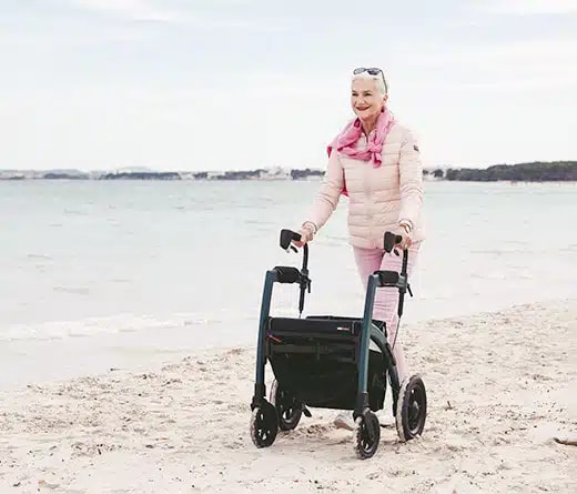 Een vrouw loopt met de Rollz Motion Performance over het strand