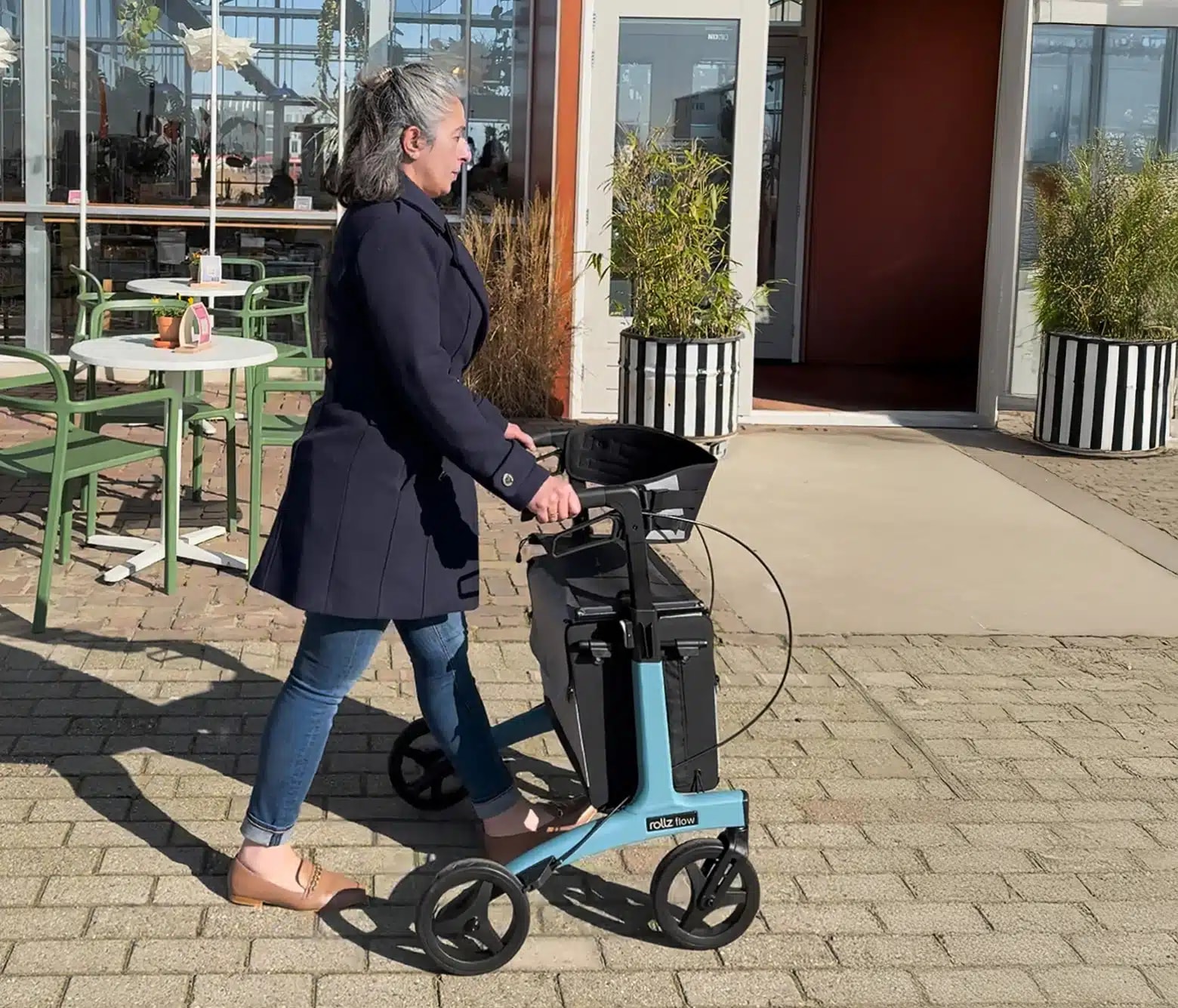 Een vrouw loopt met de Rollz Flow langs een terras