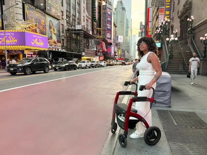 Een jonge vrouw in het wit staat met haar rode Rollz Motion Performance op Times Square in New York.
