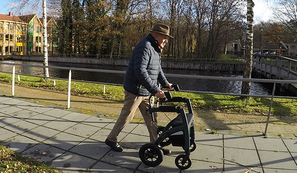 Parkinsonpatiënt die met een Parkinson-rollator loopt om freezing te overwinnen